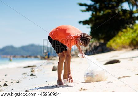Plastic Garbage. Sea And Ocean Pollution. Beach Clean Up. Young Man Picking Used Plastic Bottles On 