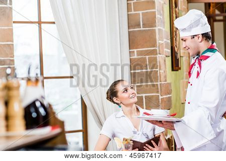 Chef bringt eine Schüssel hübsche Frau in einem restaurant