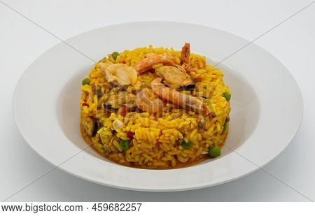 Traditional Spanish Paella In A White Disch Isolated On White Background.