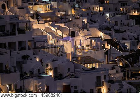 Imerovigli, Santorini, Greece - July 1, 2021: Illuminated Whitewashed Houses With Terraces And Pools