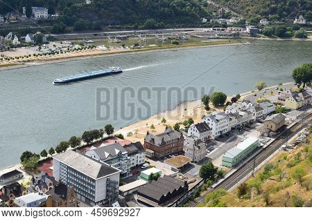 Sankt Goarshausen, Germany - 08 04 2022: Sankt Goarshausen Station Area With A Cargo Ship Passing
