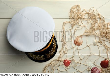 Peaked Cap, Net And Shells On White Wooden Background, Flat Lay