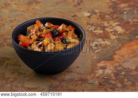 Chicken Yakissoba In Black Ceramic Bowl On Rusty Slate