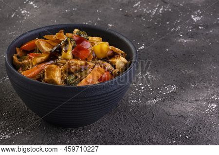 Chicken Yakissoba In Black Ceramic Bowl On Black Background