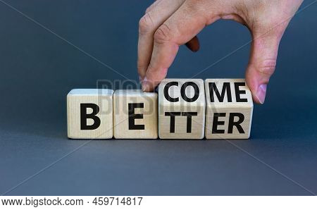 Become Better Symbol. Businessman Turns Wooden Cubes And Changes The Concept Word Better To Become. 