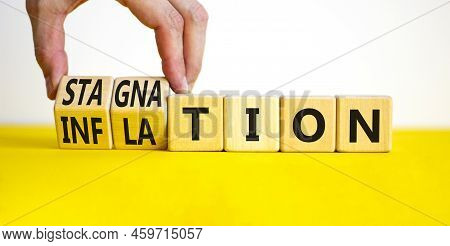 Inflation And Stagnation Symbol. Businessman Turns Cubes, Changes The Word Inflation To Stagnation. 