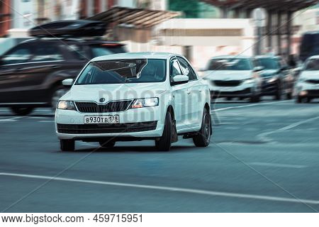 Man Driving White Skoda Rapid On City Street. Driver Driving His Car In Turning. Front Side View. Mo