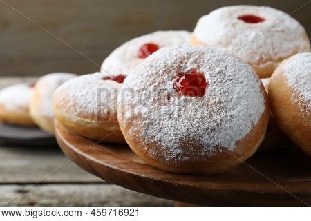 Delicious Donuts With Jelly And Powdered Sugar On Wooden Pastry Stand, Closeup