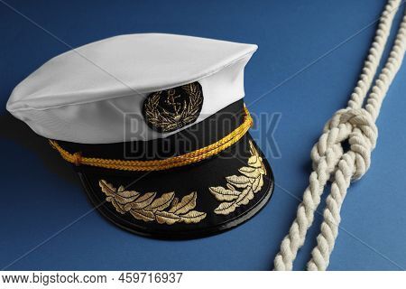 Peaked Cap With Accessories And Rope On Blue Background