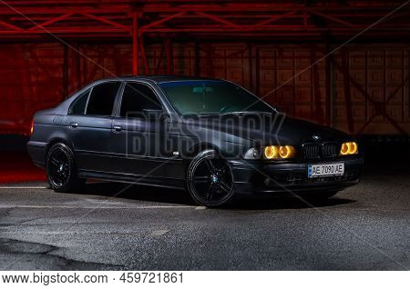 Krivoy Rog, Ukraine - August 6, 2022: Photo Of Black Bmw E39 On The Pavement At Night With The Inclu