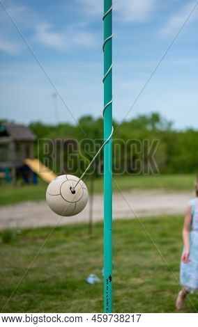 Tetherball Sitting Idle Next To The Pole In A Backyard.