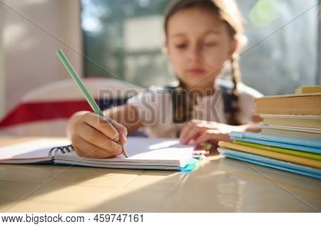 Details: Hand Of A Blurred Schoolgirl, First Grader Holding A Pencil, Making Notes On Copybook While