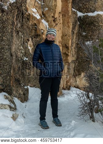 Female Hiker In Blue Coat Tilts Head And Smiles