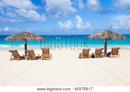 Stole og paraply på en smuk tropisk strand på Anguilla, Caribien