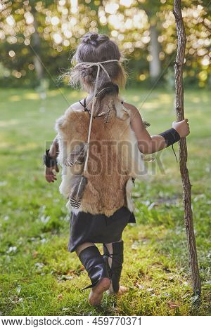 Cute Baby Dressed In The Clothes Of Primitive People With Combat Staff