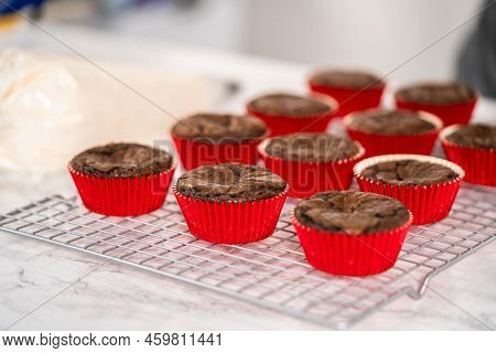 Piping Peppermint Buttercream Frosting On Top Of The Chocolate Cupcakes And Decorating With Crushed 