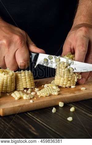 The Chef Cuts The Boiled Maize With A Knife. Corn Is An Excellent Dietary Breakfast Or Lunch. Workin