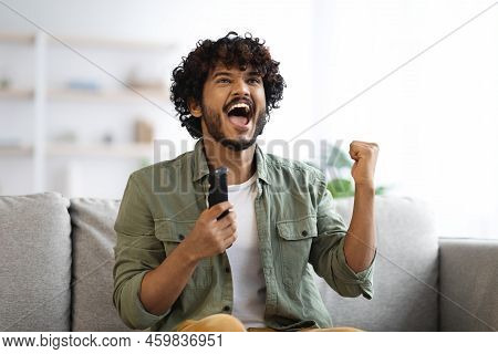 Indian Man Cheering At Football Game On Television At Home