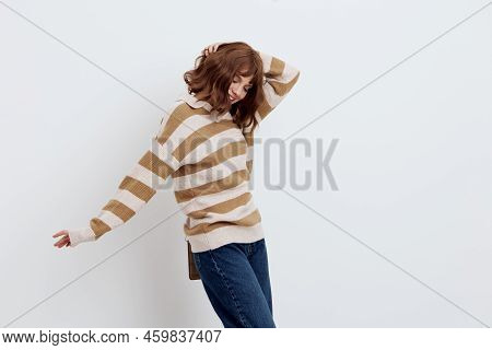 A Pretty Sweet Woman Stands On A Light Background In A Striped Sweater And A Bag On Her Shoulder, Pu