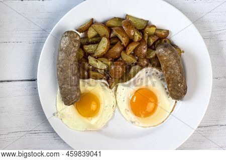 Two Fried Eggs Served With Italian Sausage And Homefries