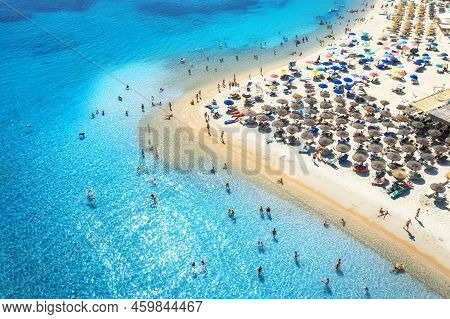 Aerial View Of Colorful Umbrellas On Beach, People In Blue Sea