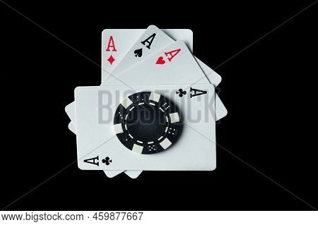 Poker Cards With A Winning Combination Of Four Of A Kind Or Quads And A Chip On A Black Table In A C