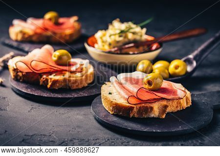 Roasted Bread Or Open Sandwich With Garlic Butter Spread And Serano Ham And Olive On Dark Background