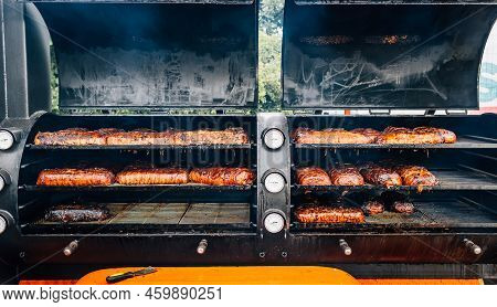 Large Barbecue Smoker Grill With Grilled Meat Wrapped With Bacon. Street Food.