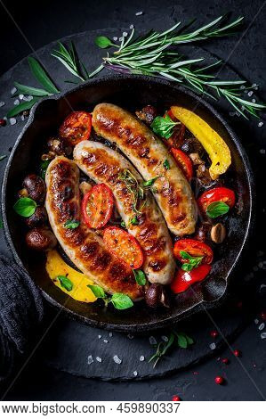 Grilled Sausages And Vegetables With Herbs In Iron Pan