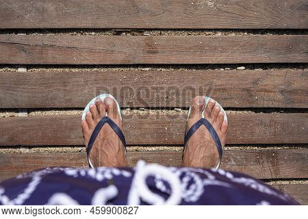 Mans Feet In Flip Flops On Wooden Boardwalk. Top View. Flat Lay. Empty Space, For Text Or Logo