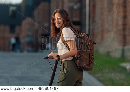 Young Woman Riding Electric Scooter In City Urban Street