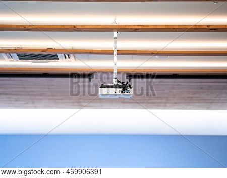 White Projector Hang It On The Ceiling In The Middle Of The Meeting Room.