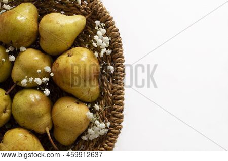 Yellow Pears In The Woven Basket With White Flowers Close Up Top View With Copyspace