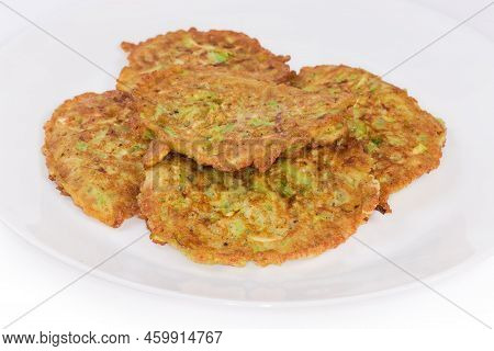 Fried Small Thick Savory Zucchini Pancakes On The White Dish On A White Background Close-up In Selec