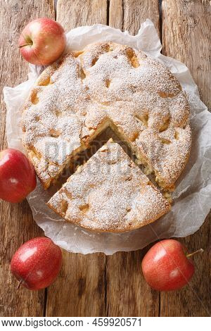 Tasty Homemade Sharlotka Apple Pie Close-up On A Parchment Paper On The Table. Vertical Top View Fro