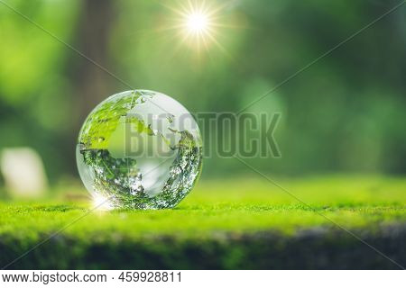 Sunlight With Earth Sphere Crystal Or Sustainable Globe Glass On Green Moss Nature Background In Eco