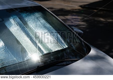 Closeup Of Protective Reflective Surface Under The Windshield Of The Passenger Car Parked On A Hot D