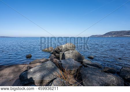 Boulders As A Part Of A Wave Breaker In A Lake. Picture From Lake Vattern, Sweden. Blue Water And Sk