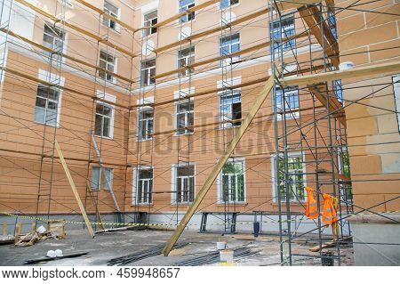 Scaffolding Next To The Outer Wall Of An Urban Four-story Building. Capital Repairs, Reconstruction 