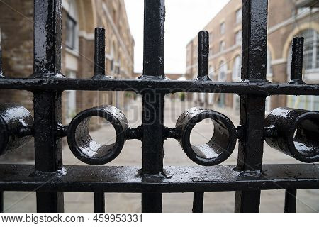 Solid Black Metal Fence With Behind It Noble Estate And Clean Courtyard Parking As Concept For Gated