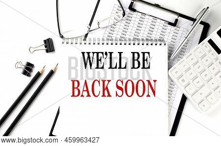 We'll Be Back Soon Word On A Notepad With Clipboard , Chart And Calculator, Business Concept