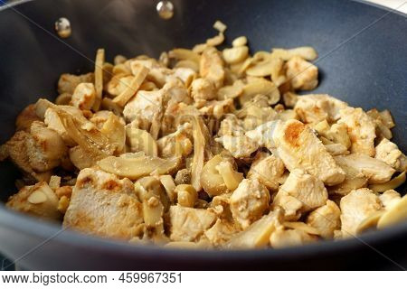 Chopped Chicken Fillet With Mushroom Fried On Frying Pan. Cooking Process Close Up.