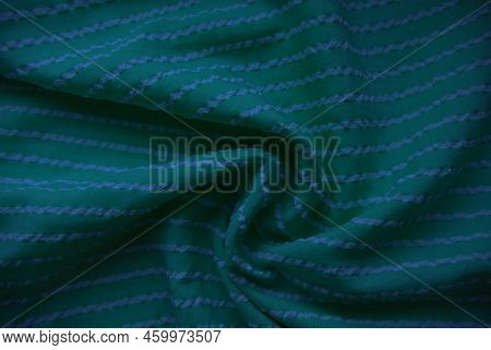 Folds Of Green Fabric With White Stripes.