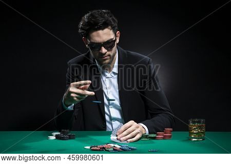 Caucasian Brunet Pocker Player At Pocker Table With Chips And Cards While Thoughfully Sitting With H