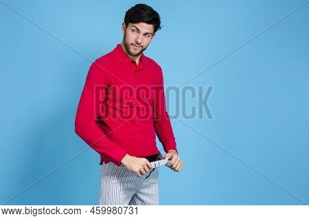 Youth Funny Concepts. Caucasian Handsome Brunet Man In Striped Underware Pulling Pants While Looking