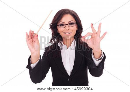 femme d'affaires jeune mène avec une baguette et un sourire. sur fond blanc