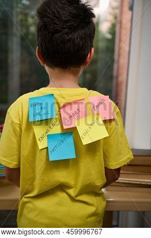 Rear View Of A Smart Schoolboy With Colored Paper For Notes Glued On His Bright Yellow T-shirt With 