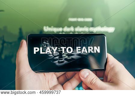 Russia Moscow 25.12.2021 Play To Earn Logo In Mobile Phone. Concept For Blockchain Nft Ethereum Cryp