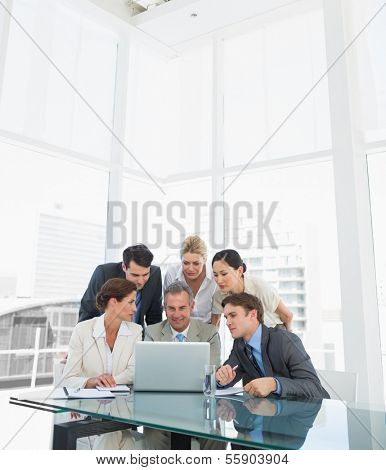 Group of business colleagues with laptop at office desk