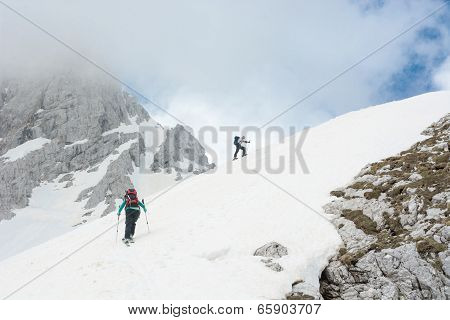Skiiers Ascending Mountain Slope